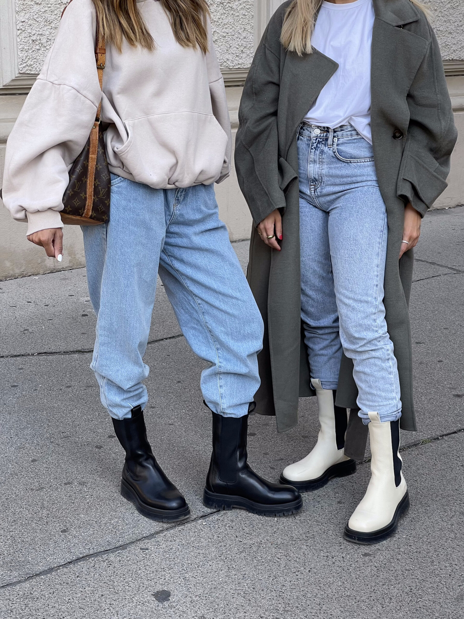 Lower body of the two influencers Sonia Dhillon and Christina Biluca. Christina Biluca is on the right, wearing denim mom jeans, a white t-shirt, a khaki trench coat and the CPH1000 in vitello ecru. To her left is Sonia Dhillon wearing light denim mom jeans, a cropped hoodie in beige, the CPH1000 in clear black and carrying a Louis Vuitton around her right shoulder.