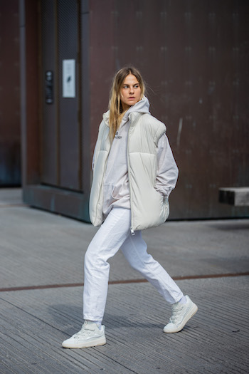 You can see @alessawinter running on the streets of Copenhagen in her all white look. She is wearing a white puffer vest, white jeans, and a white hoodie in combination with the CPH201 leather mix white.