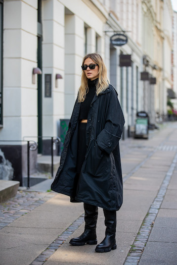 You can see @alessawinter standing on streets of Copenhagen in her all black everything look. She is wearing a black oversized raincoat from Balenciaga, a black turtleneck sweater, a black skirt, black sunglasses and the CPH551 in vitello black.