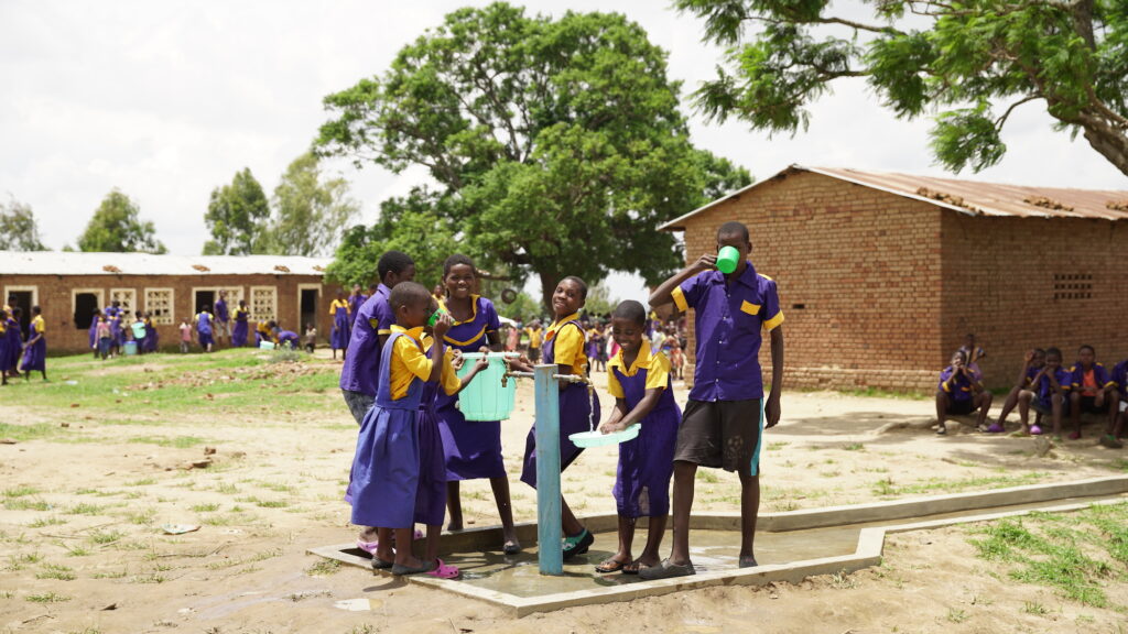 UNICEF campaign “Living Schools – Promoting sustainable climate change action for resilient learners in Malawi” On the picture you can see Children drinking and pumping fresh water.