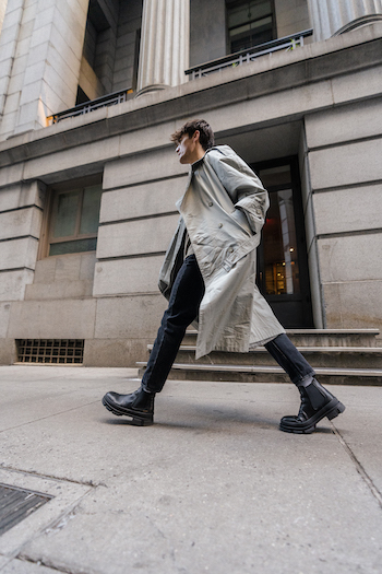 Jonas Kautenburger walking on the streets of New York City. He is wearing his Copenhagen Studios men boots CPH735M vitello black and combined it with a long Trenchcoat and a black denim jeans.
