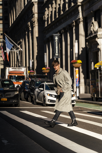 Jonas Kautenburger walking on the streets of New York City. He is wearing his Copenhagen Studios men boots CPH735M vitello black and combined it with a long Trenchcoat and a black denim jeans.