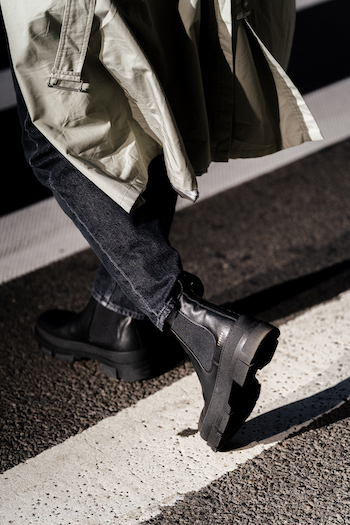 Jonas Kautenburger walking on the crosswalk in New York City. You can see a section of his outfit. He wears his CPH735M vitello black men boots in combination with a long trench and a black denim jeans.