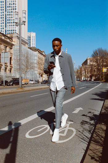 Campaign Picture from our Analogue Street Style Shooting. Model is crossing the street in Frankfurt and wearing white Copenhagen Studios Sneakers and a grey suit.
