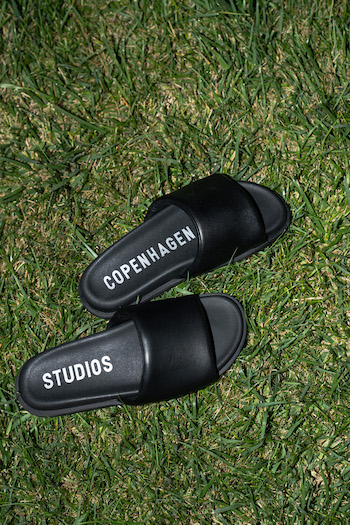 A picture from the High Summer Campaign from Copenhagen Studios with the winner go our challenge at THOC. On the picture you can see black sandals on the grass.