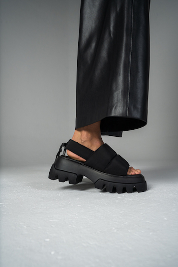 A picture from a Lookbook Shooting for Copenhagen Studios. The Model is wearing a leather pants in black and chunky sandals with nylon: CPH229.