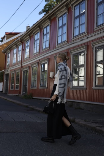@tineandreaa strolling through the streets of Oslo and wearing her new scarf CPH SHAWL 1 wool mix grey in combination with a black skirt, a white wool sweater and CPH183 vitello black boots.