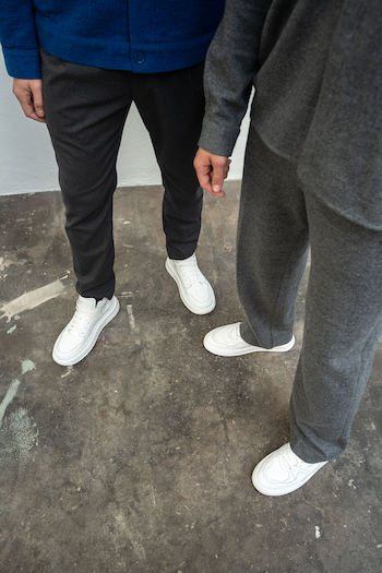 Our two male models Bartosz and Rafael are matching on set while wearing some of our new favourite sneaker. One of them is our new CPH73M vitello white. As you can see in the shot we paired it with a dark trousers and a blue jacket to create a nice contrast to the shoes. Bartosz, the model on the right side is wearing one of our all time classics. CPH811M vitello white and combined it with a grey cotton suit and a short blue beanie to break up the fit.