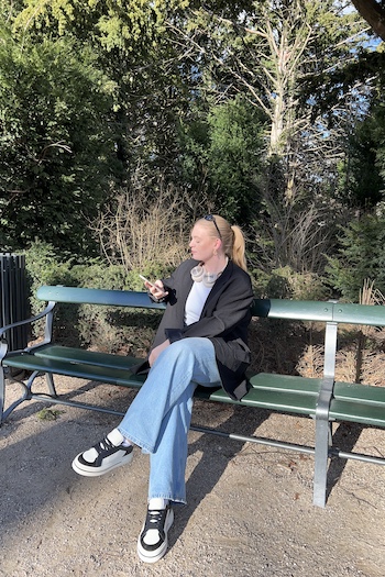 mariadjonsson wearing our CPH181 leather mix black/cream beige sitting on a bench in Copenhagens well known park: Frederiksberg Garden. She enjoys her own company wearing a casual outfit, a black suit and classic denims with our comfortable sneaker.