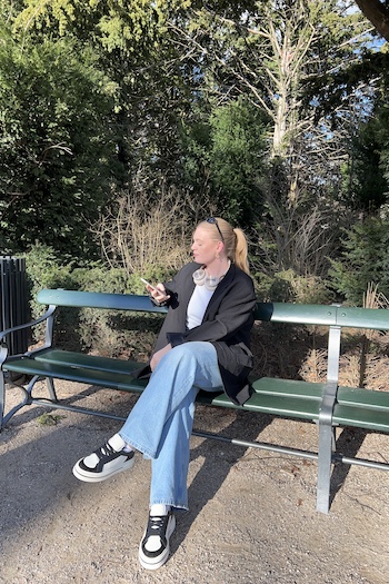 mariadjonsson wearing our CPH181 leather mix black/cream beige sitting on a bench in Copenhagens well known park: Frederiksberg Garden. She enjoys her own company wearing a casual outfit, a black suit and classic denims with our comfortable sneaker. 