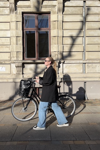 The young danish content creator mariadjonsson is showing us around her favourite spots in Copenhagen. 
She is standing in front of her bike wearing our season favourite, the CPH181 leather mix black/cream beige. 