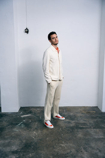 A very handsome man is wearing an overall beige outfit and added our CPH428M material mix orange.