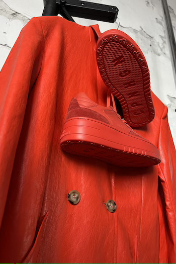 CPH X LALA BERLIN leather mix paprika hanging on a hanger and a matching red trenchcoat.