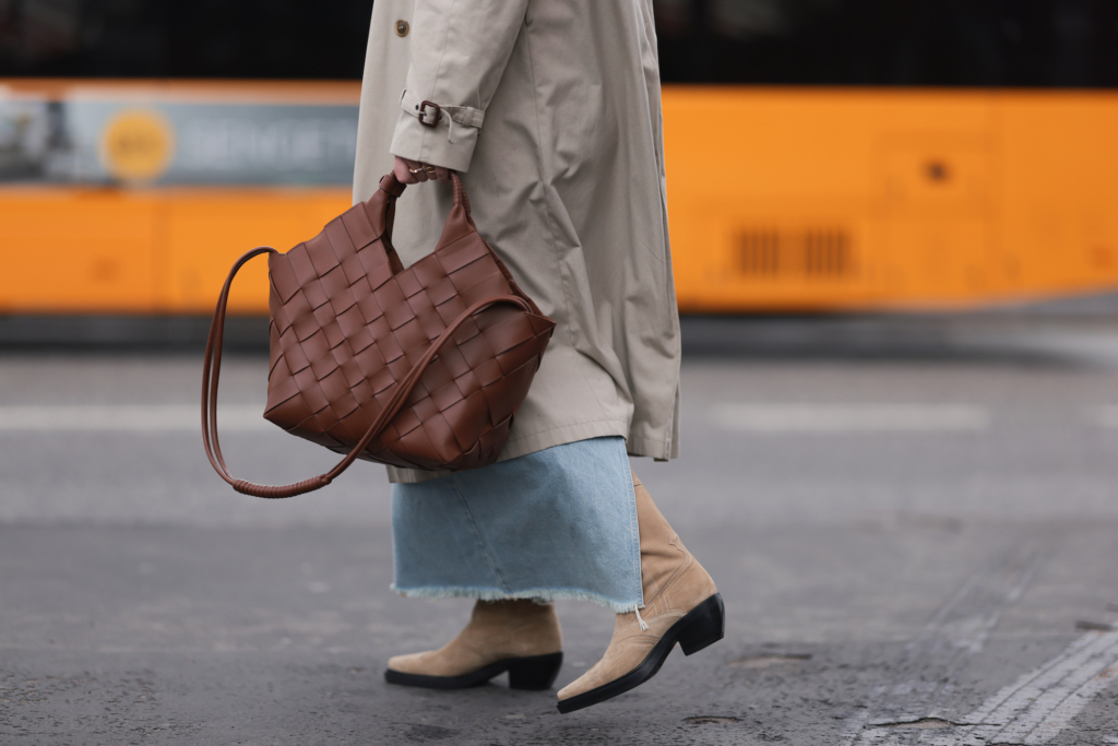 A famous influencer in Copenhagen wearing the soon to be back CPH233 suede sand. in her right hand there is a brown bag. 