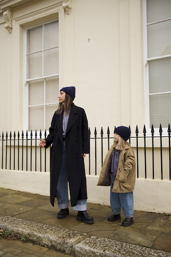 The young creator Emily and her daughter both wearing our CPH686 vitello black standing in front of a fence.