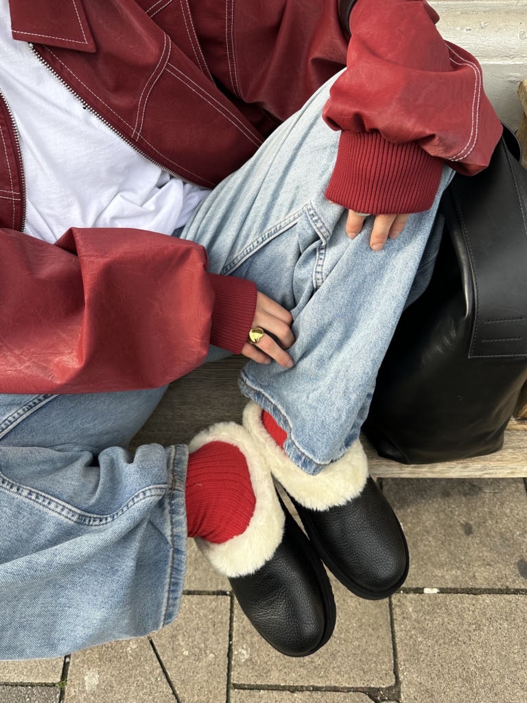 The content creator Lara is wearing our Sliders CPH248 with black leather and paired it with a red biker jacket.