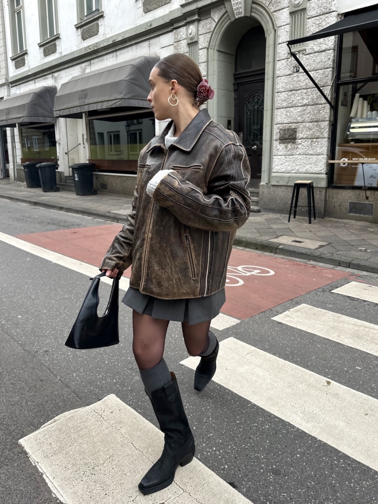 On the streets of duesseldorf, Germany Lara is wearing a brown leather jacket paired with our CPH283 waxed nabuc black.