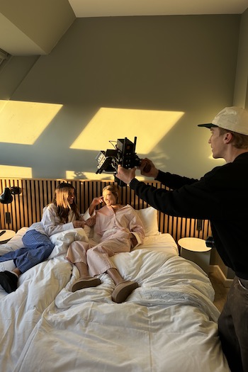 The two creators and the photographer laying in bed at their hotel room. Both wearing our CPH24ß suede sliders.