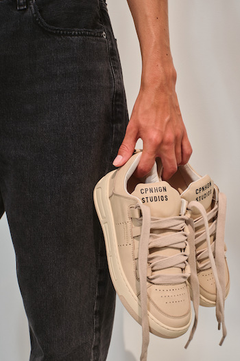 The picture Shows the CPH213 soft vitello nude being held by a model next to its legs. She is wearing black jeans.