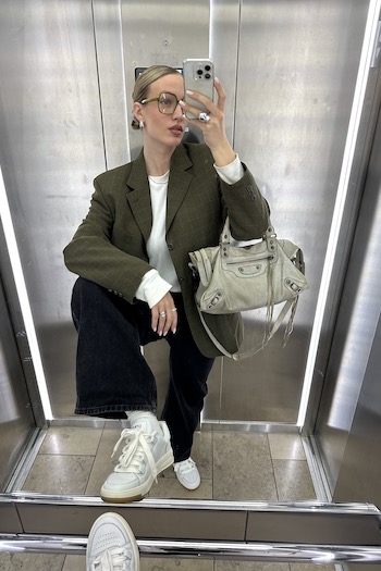 The young creator Marleen from Münster, Germany taking a picture in an elevator, wearing a Blazer, glasses, a vintage bag and our CPH213 soft vitello white retro skater sneaker. 