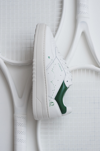 The CPH LONDON leather white/green is in focus & laying on a racket.