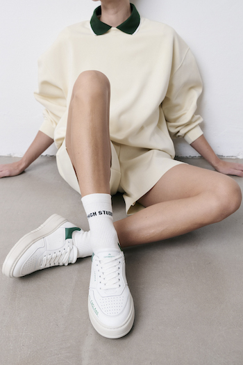 You can see a model posing in the CPH LONDON, wearing a beige outfit with green details.