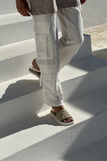 The images shows a model walking down steps in our CPH710 nabuc nature combined to cargo linen pants.