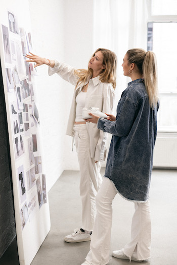 In this image, you can see Toni Garrn looking at her collection moodboard while talking to Copenhagen Studios.