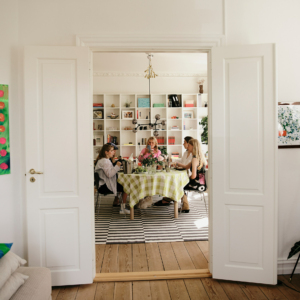 The picture shows the view from the living room into the dining room, where content creator Maria Halse and her friends are sitting at a table having brunch and wearing our styles.