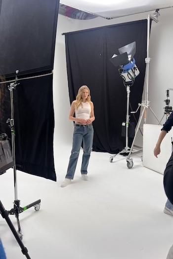 Toni on set wearing a white tank top and jeans shorts. She combined to our soon launching collection TONI X CPH STUDIOS!
