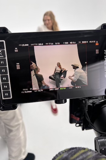 Toni Garrn on set. We can see her through the lease of the Photographers Camera laying on a chair.