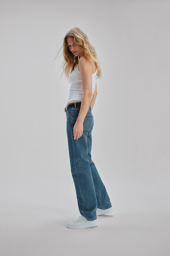 Toni Garrn wearing the "CPH253 x Toni Garrn leather/white" sneaker to a tank top and wide leg jeans.