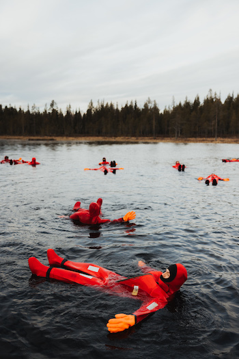 This image shows how our guests are floating on icy waters in red thermal suits. 