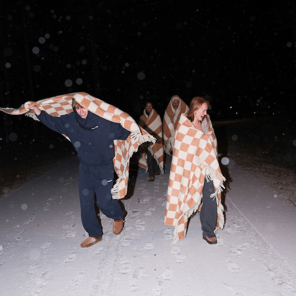 This image shows our Hygge House 2024 guests running outside in the snow.